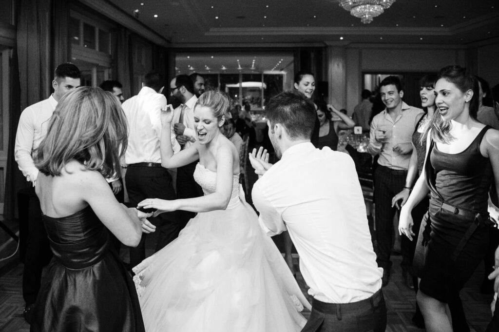 Bride joyfully dancing, encircled by applauding friends during the lively celebration.