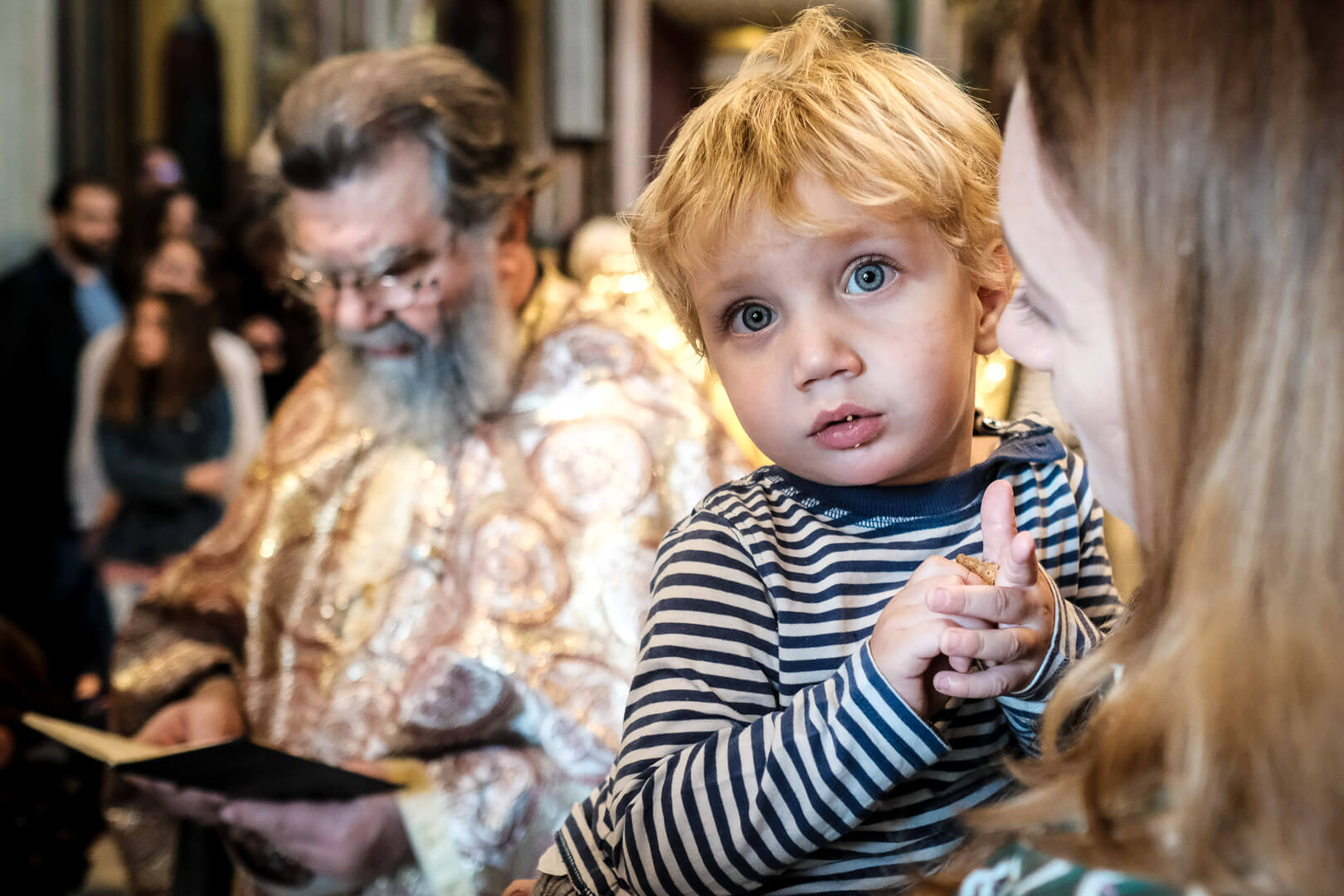 Captivated by faith: a child's innocent gaze takes in the sacred atmosphere of the ceremony. 