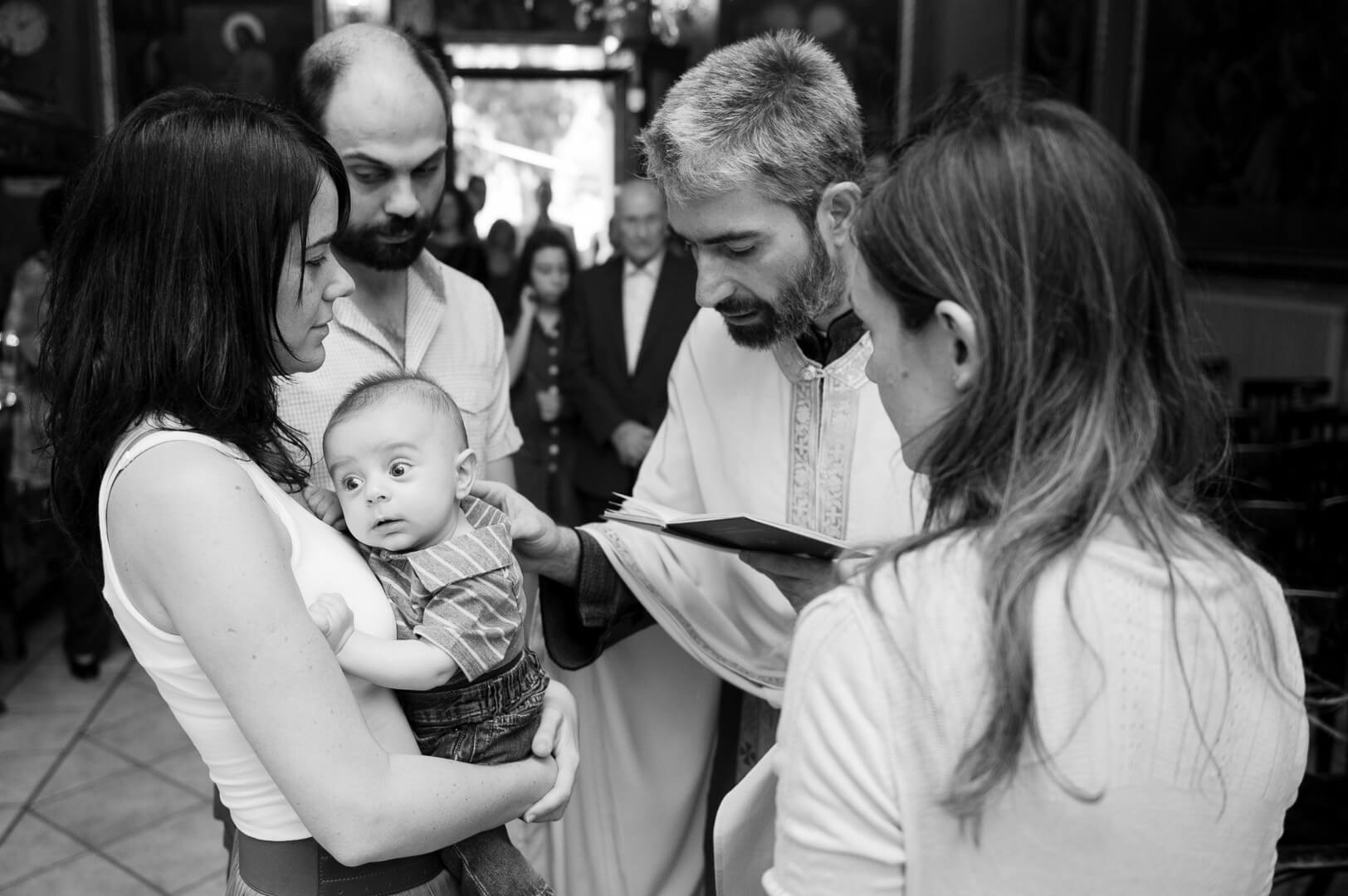 Christening in Athens, baby blessed by priest